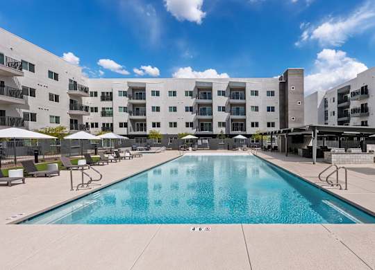 A large swimming pool in front of apartment buildings.