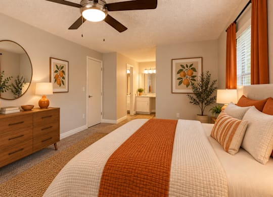 A bedroom with a large bed and a ceiling fan.