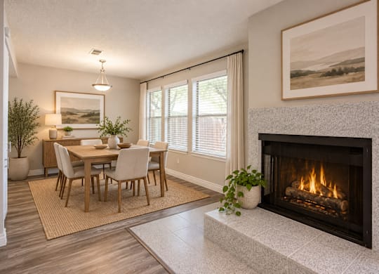 A modern dining room with a fireplace and a painting on the wall.