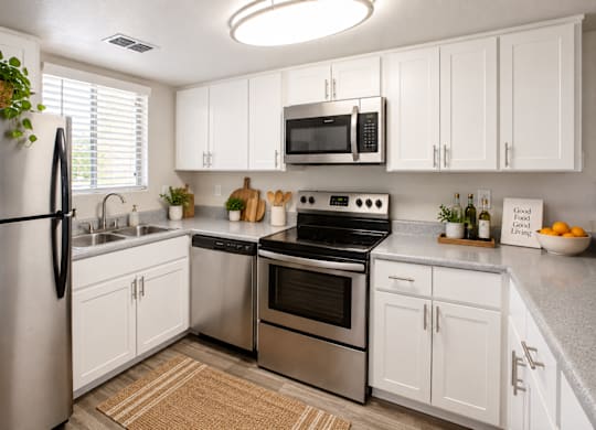 A kitchen with white cabinets and stainless steel appliances.