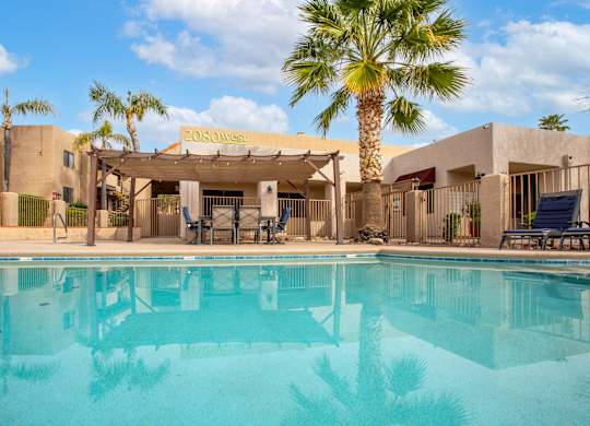 A pool in front of a building with a palm tree.
