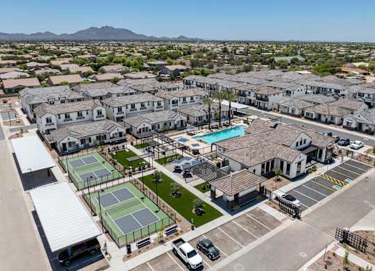 A large residential complex with tennis courts and a swimming pool.