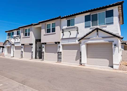 A row of houses with white garage doors.