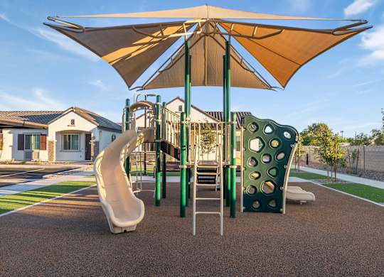A playground with a slide, swings, and a canopy.