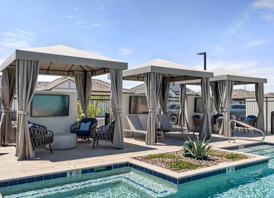 A pool area with a white canopy and a small pond.