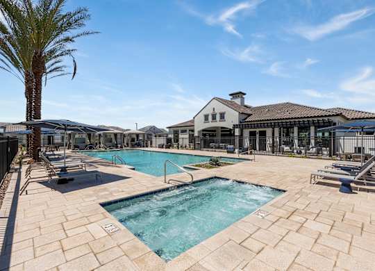A large outdoor swimming pool surrounded by a stone patio.