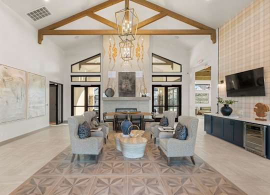 A modern living room with a large rug and a chandelier.
