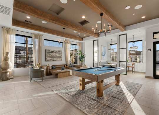A large, well-lit room with a pool table and comfortable seating.
