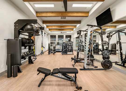 A gym with a variety of equipment including weights and machines.