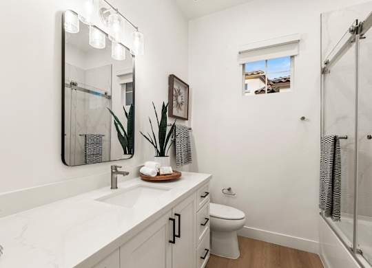 A bathroom with a white counter top and a toilet.