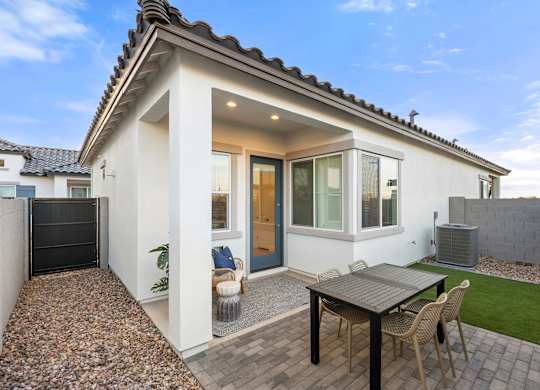 A small white house with a patio and a table.