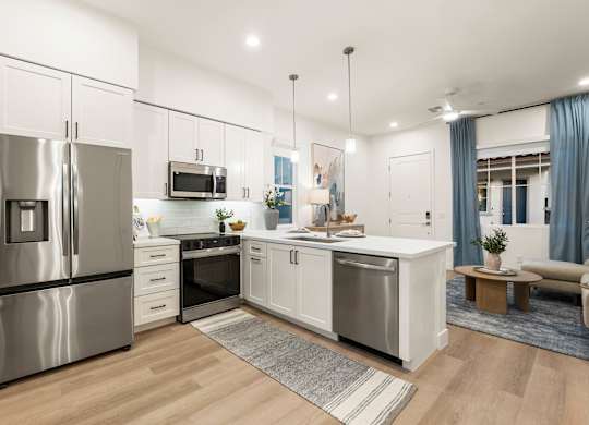A modern kitchen with stainless steel appliances and white cabinetry.