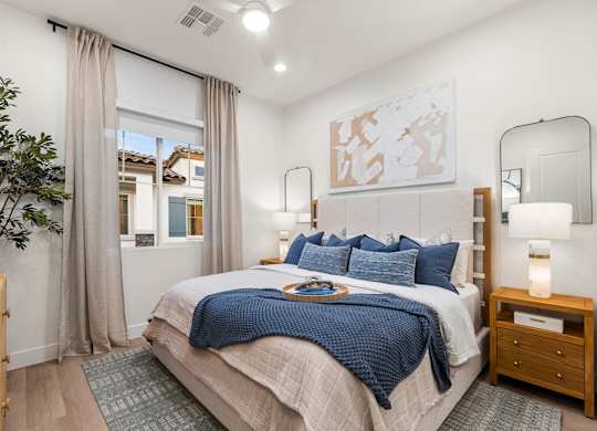 A bedroom with a large bed and a mirror on the wall.