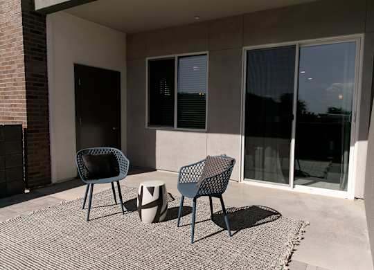 A patio with two chairs and a table.