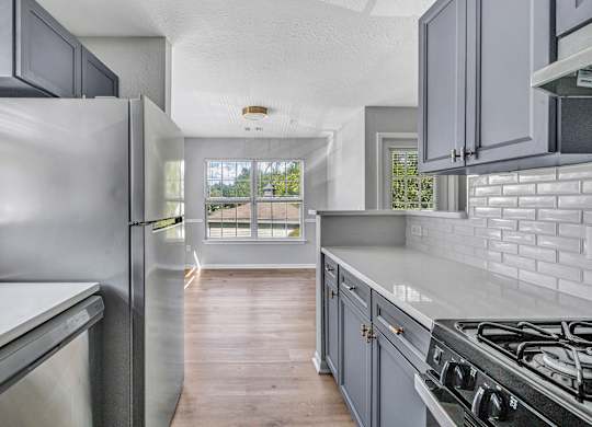 A modern kitchen with a stainless steel refrigerator and a wooden floor. at Ardenwood Apartments, North Haven