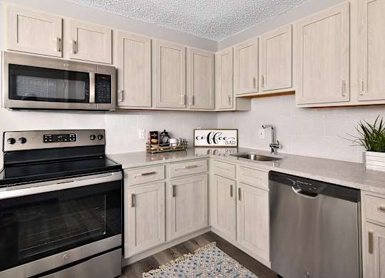 a kitchen with stainless steel appliances and white cabinets at Encore 99, East Haven, CT, 06512