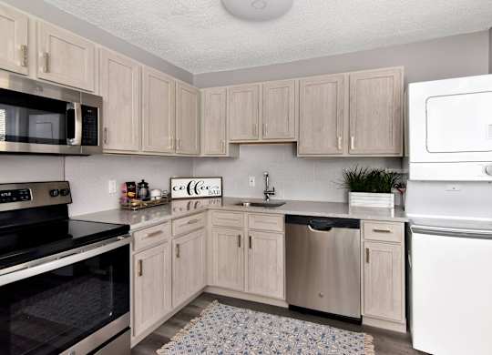 a kitchen with white appliances and wooden cabinets at Encore 99, East Haven, CT, 06512