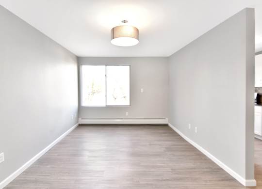 an empty living room with white walls and a window at Springwood Gardens, New Britain, CT