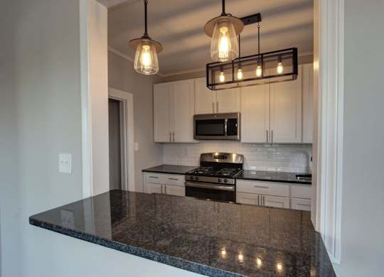 a kitchen with white cabinets and a counter top at The Packard, Connecticut