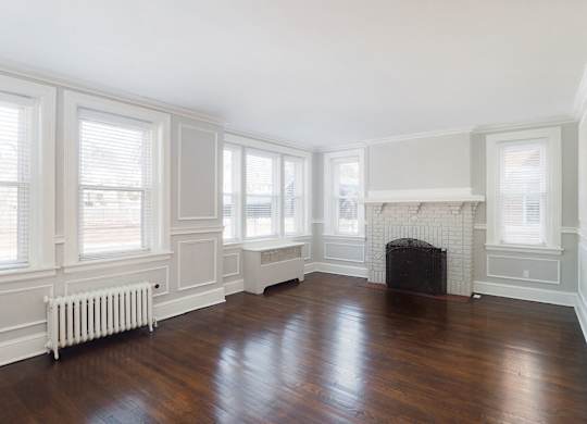 a living room with a fireplace and wooden floors at The Packard, West Hartford, CT, 06119