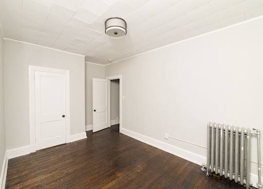 an empty room with a radiator and white walls at The Packard, West Hartford, CT, 06119