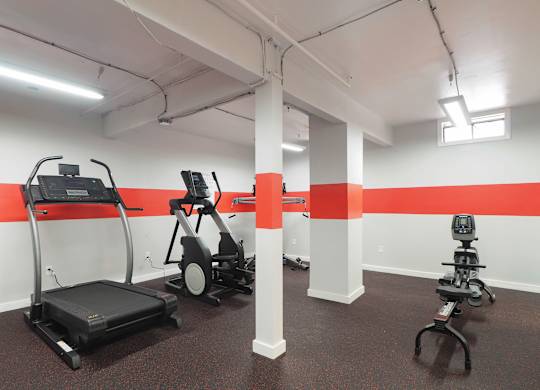a gym with exercise equipment and a red stripe on the wall at The Packard, West Hartford, 06119