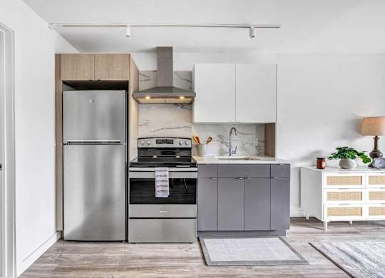 a small kitchen with stainless steel appliances and white cabinets at Up House, Farmington, 06032