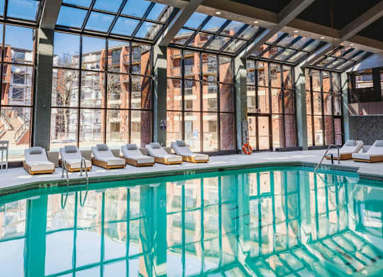 a swimming pool in front of a building with large windows at Up House, Connecticut, 06032