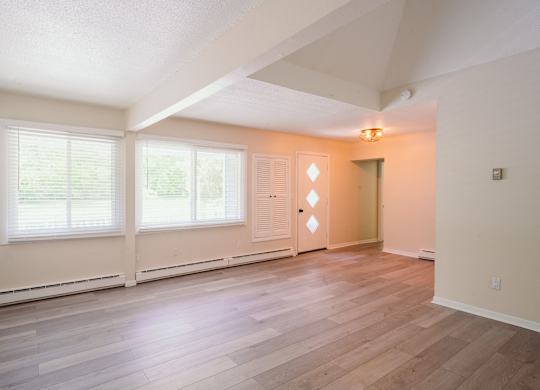 a spacious living room of an empty home with wood flooring and large windows at Woodbury Knoll, Woodbury, CT 06798