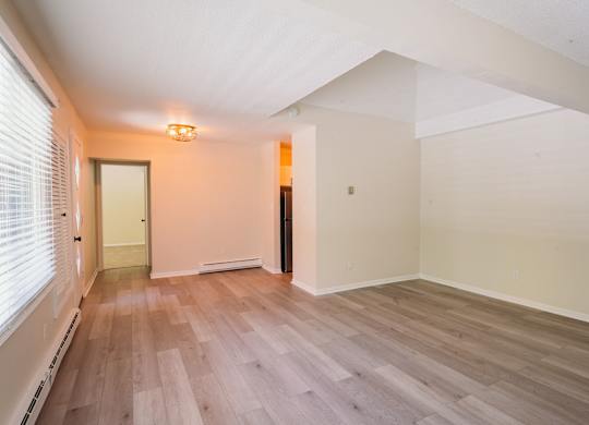 an empty living room with wood floors and a window at Woodbury Knoll, Woodbury, CT