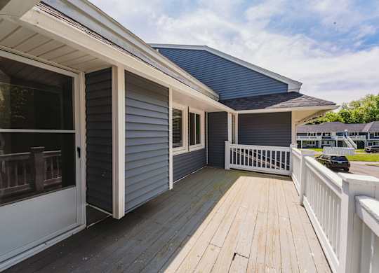 a house with a deck and a blue roof at Woodbury Knoll, Connecticut, 06798