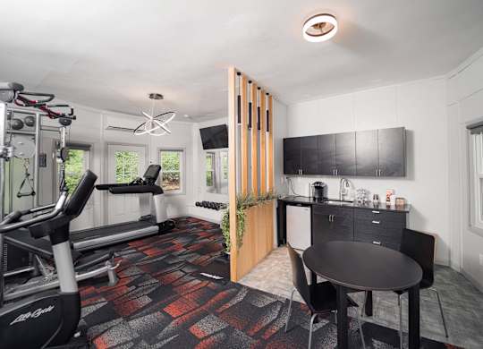 a workout room with a table and chair and a treadmill at Woodbury Knoll, Woodbury, CT