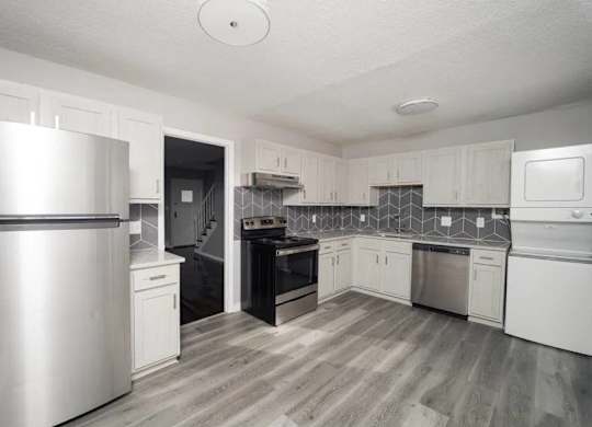 a kitchen with stainless steel appliances and white cabinets at Encore 99, East Haven, CT
