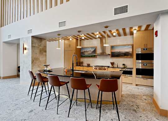 A kitchen with a bar area and chairs.