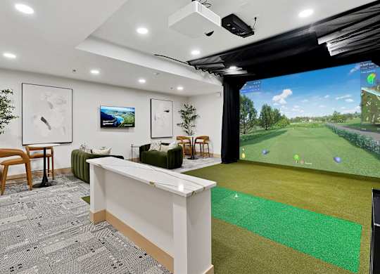 A room with a white reception desk and a large screen on the wall.