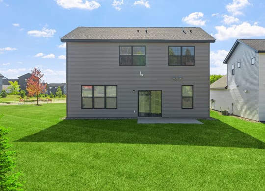 the back of a house with a green lawn