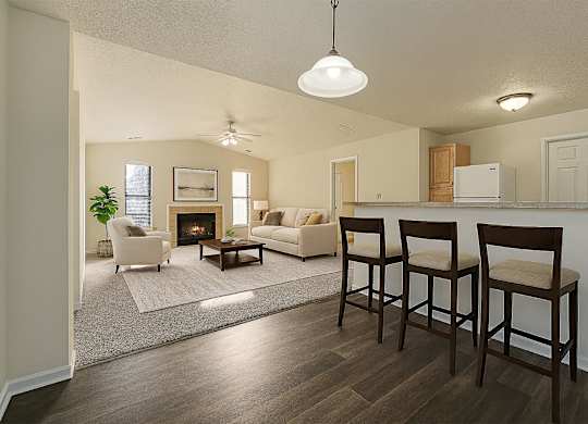 A living room with a fireplace and two chairs.