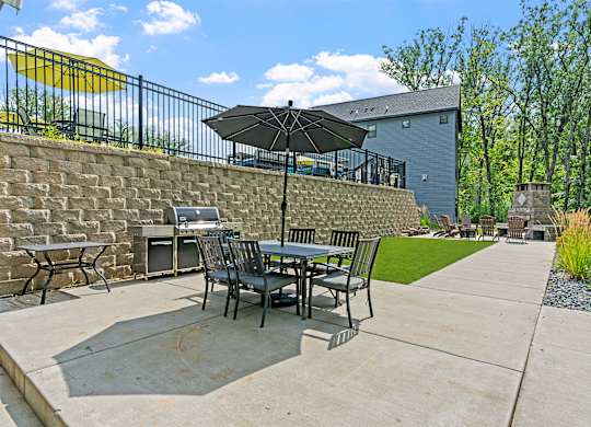 A patio with a table and chairs under an umbrella.