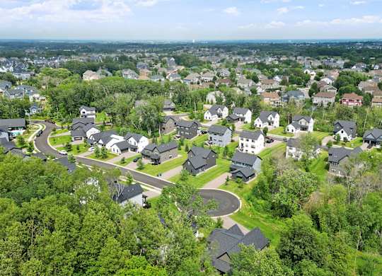 A bird's eye view of a residential area with houses surrounded by greenery.