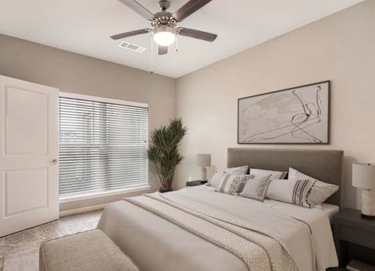 A bedroom with a large bed and a ceiling fan.