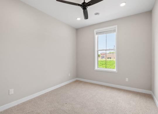 a bedroom with a ceiling fan and a window