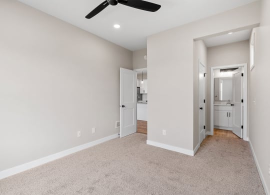 a bedroom with a ceiling fan and carpet