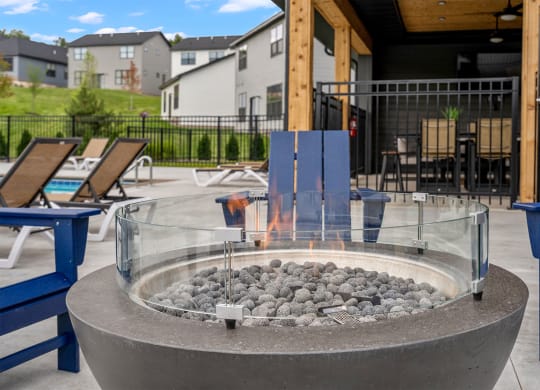a fire pit with rocks in the middle of a patio