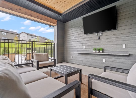 a patio with a couch and a coffee table in front of a tv