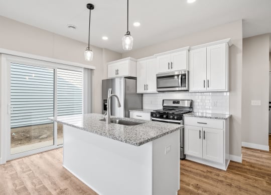 a kitchen with white cabinets and a granite counter top