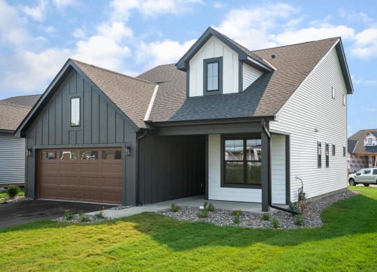 a house with a gray roof and a brown garage door