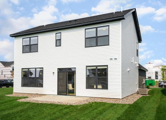 a home with white siding and a black roof