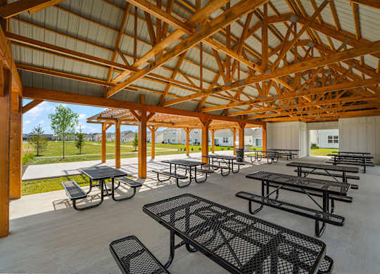 A wooden pavilion with tables and benches.