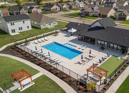 A large outdoor swimming pool surrounded by a deck and lounge chairs.