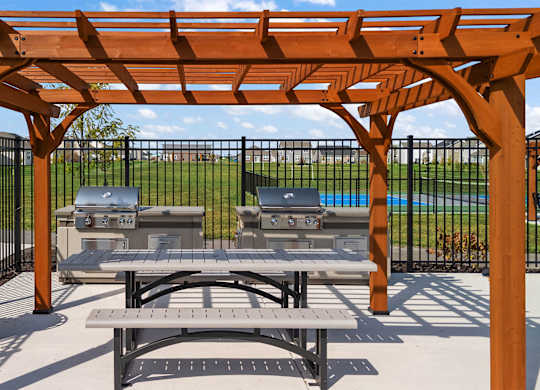 A wooden pergola with a picnic table underneath it.